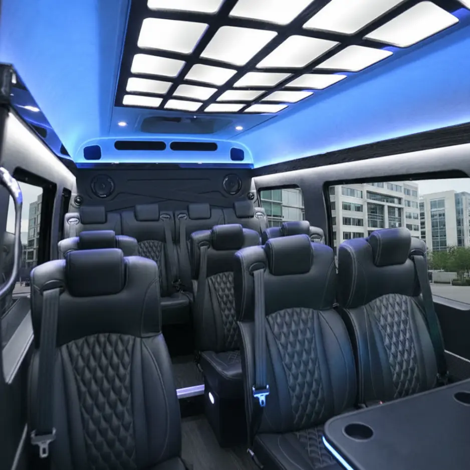 Interior of a luxury executive Mercedes Sprinter van featuring leather quilted seats, blue LED ambient lighting, and a modern ceiling design