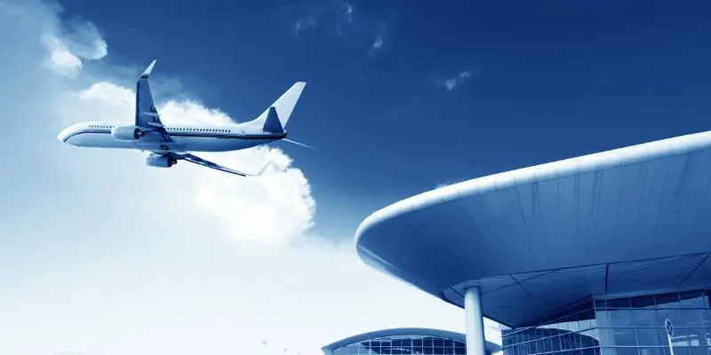 Airplane taking off over a modern airport terminal, representing luxury airport transfer services in Bellevue