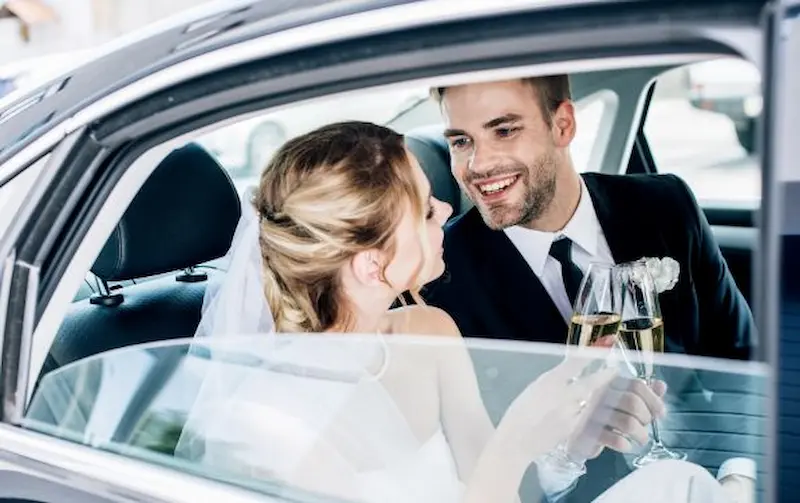 Wedding Couple smiling in car